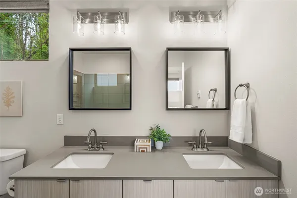 a bathroom with double vanity sinks and a mirror