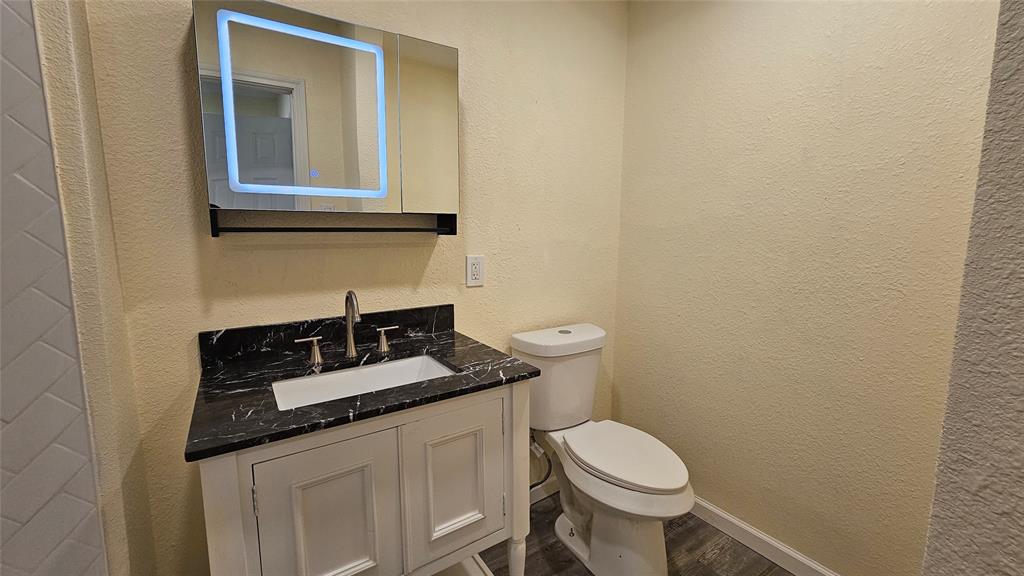 5065 Ridglea Lane, Unit 1009 Fort Worth, TX 76116 - Photo 7 of 12 a bathroom with a granite countertop toilet and sink
