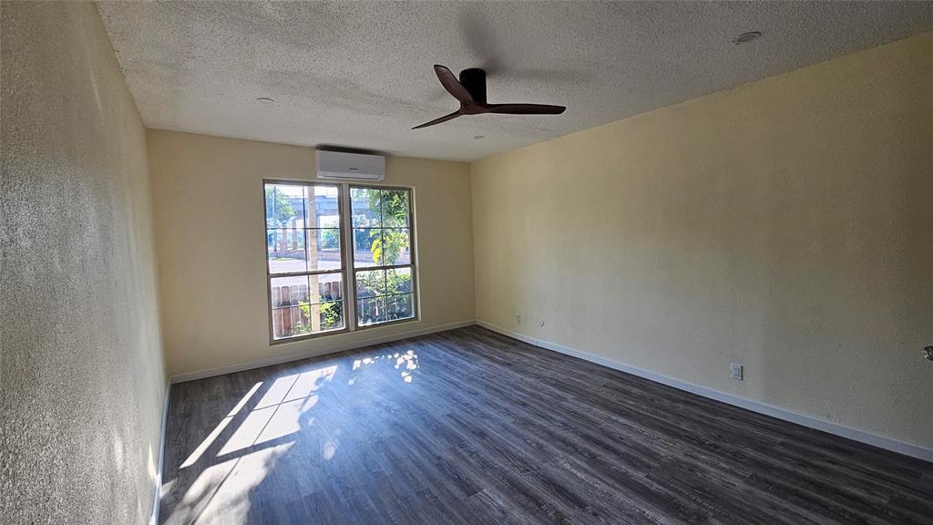 5065 Ridglea Lane, Unit 1009 Fort Worth, TX 76116 - Photo 9 of 12 an empty room with wooden floor and windows