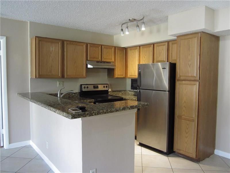751 Lyons Road, Unit 18102 Coconut Creek, FL 33063 - Photo 2 of 9 a kitchen with stainless steel appliances granite countertop a refrigerator a stove a sink and a refrigerator