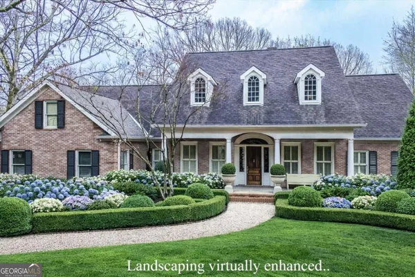 a front view of a house with a yard and potted plants