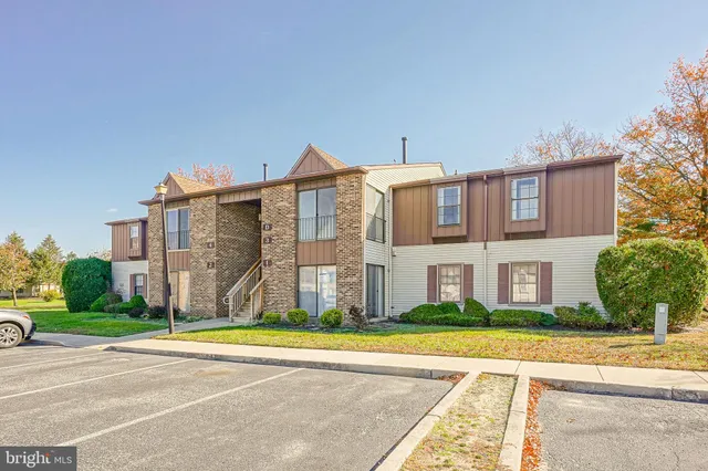 a view of a big house with a big yard and large trees