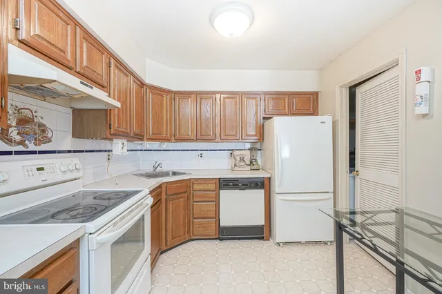 a kitchen with a sink a refrigerator and cabinets