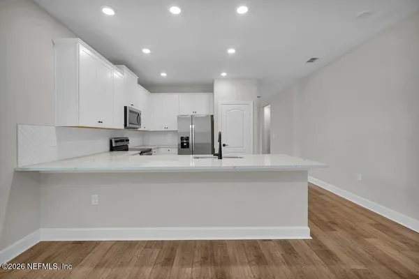 a view of kitchen with stainless steel appliances sink refrigerator and microwave