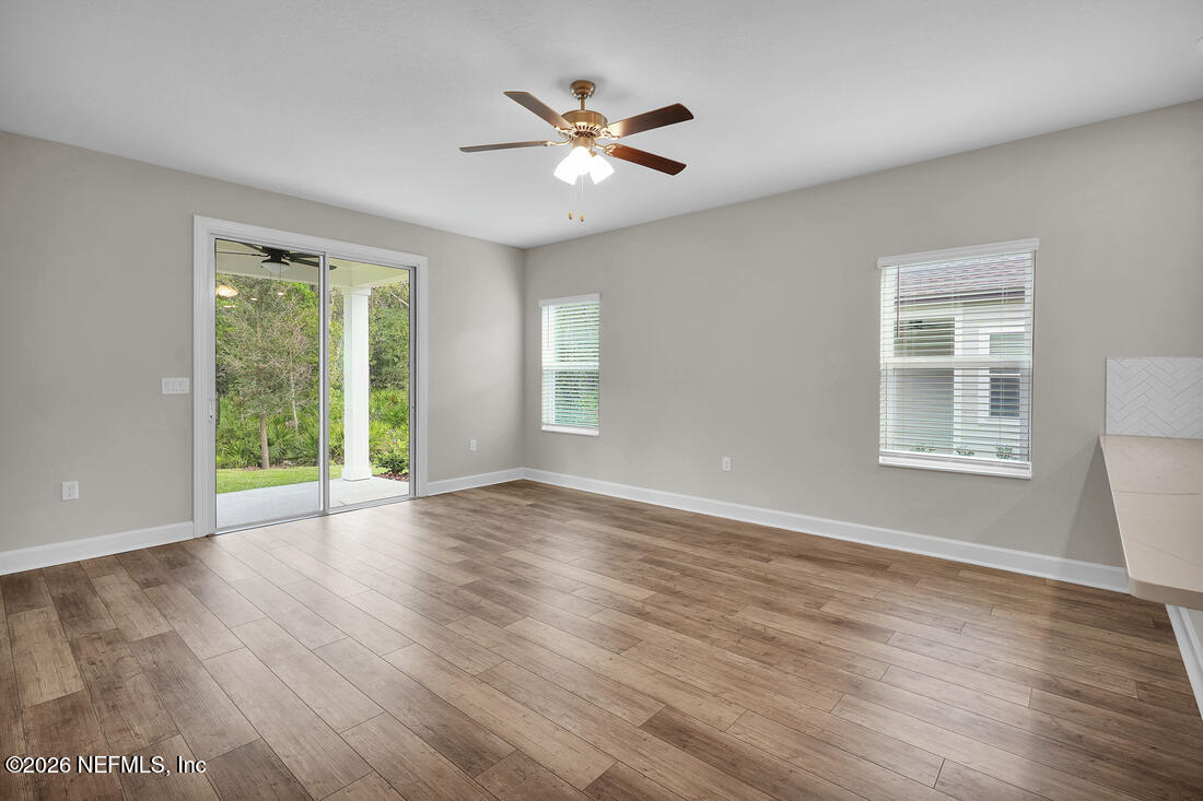 6970 Canoe Birch Road Jacksonville, FL 32219 - Photo 4 of 20 a view of an empty room with wooden floor and a window