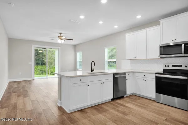 a kitchen with a sink window and stainless steel appliances