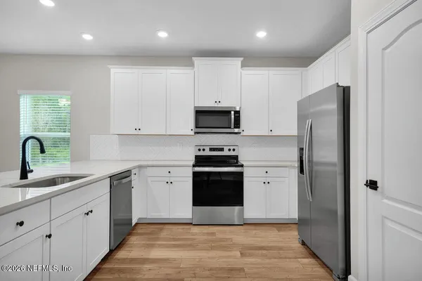 a kitchen with stainless steel appliances granite countertop a stove a sink and a refrigerator
