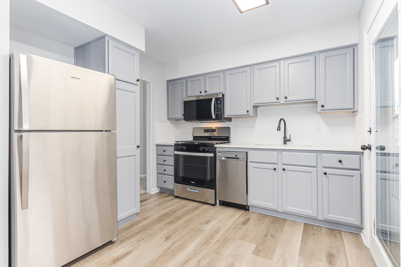 227 Hadleigh Road Bolingbrook, IL 60440 - Photo 5 of 19 a kitchen with a refrigerator sink and white cabinets