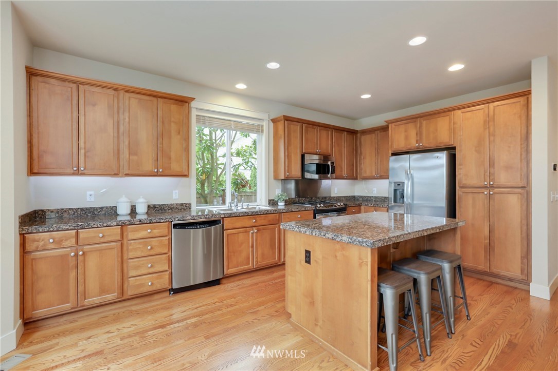 4014 167th Street Southeast Bothell, WA 98012 - Photo 12 of 39 a kitchen with stainless steel appliances granite countertop a stove top oven a sink dishwasher and a refrigerator
