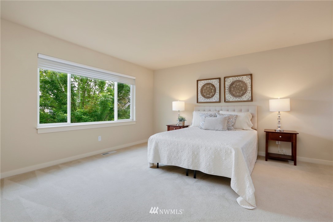 4014 167th Street Southeast Bothell, WA 98012 - Photo 20 of 39 a bedroom with a bed lamp and a large window