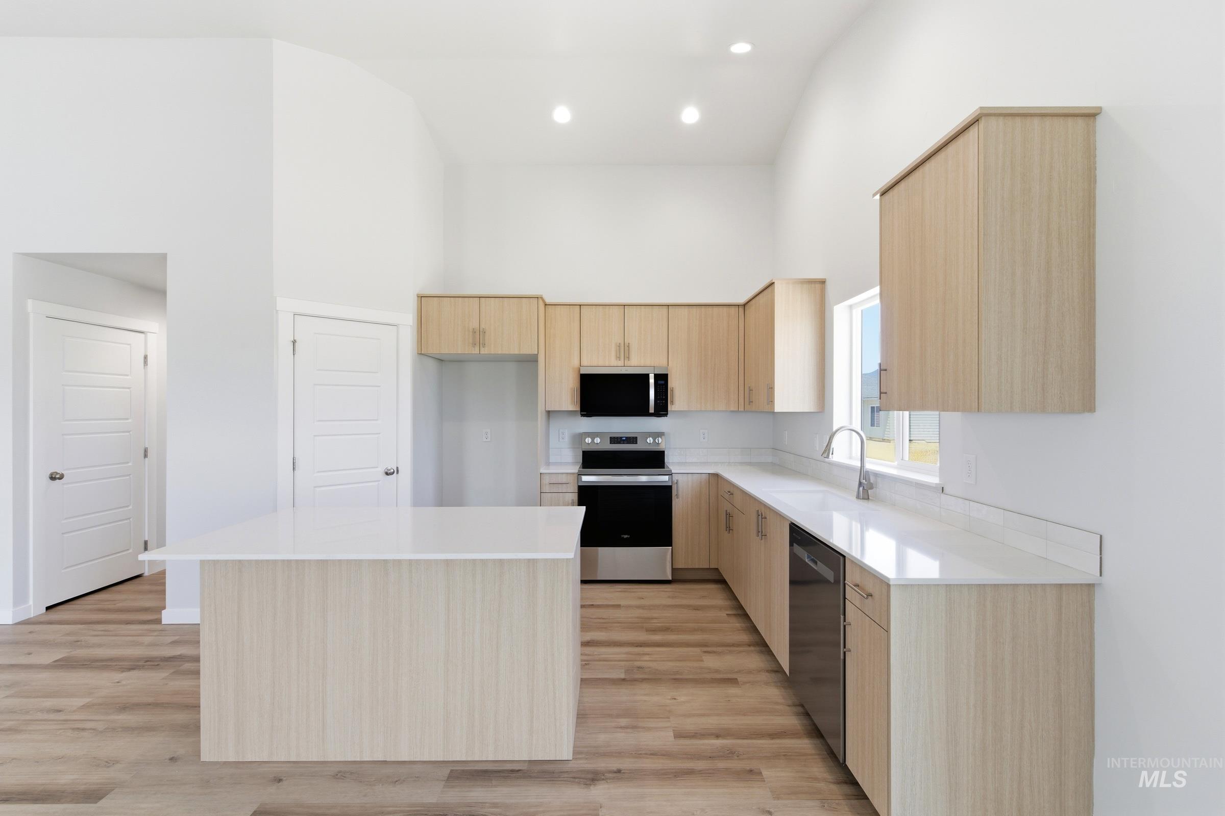 8317 South Tyrion Way Kuna, ID 83634 - Photo 5 of 22 Modern kitchen featuring light wood-finish cabinetry and a central island with a solid surface countertop