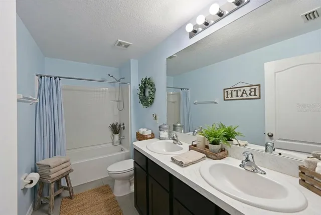a bathroom with a granite countertop sink a toilet and shower