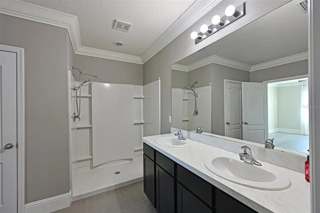 a bathroom with a double vanity sink and a mirror