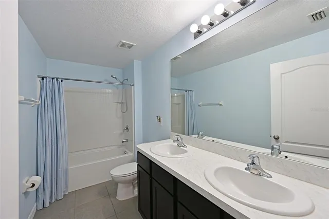 a bathroom with a toilet a sink a mirror and a shower