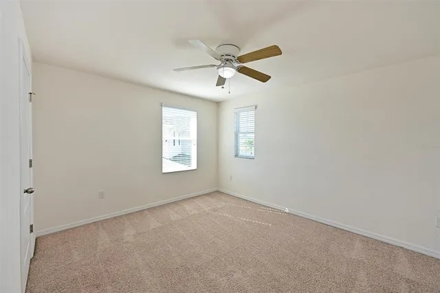 an empty room with windows and fan