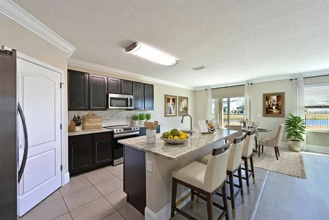 a view of kitchen with sink refrigerator dining table and chairs