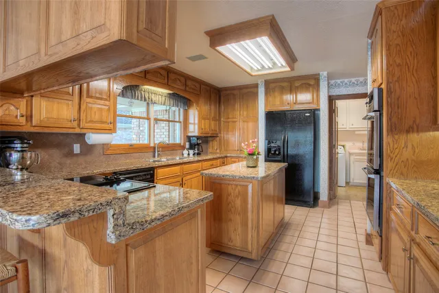 a kitchen with stainless steel appliances granite countertop a sink and a stove