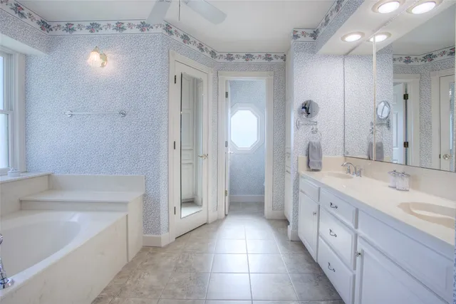 a spacious bathroom with a granite countertop sink a mirror a shower and a bathtub