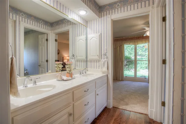a en suite bathroom with 2 sink flowerpot and a mirror