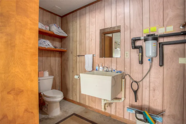 a bathroom with a granite countertop toilet and a sink