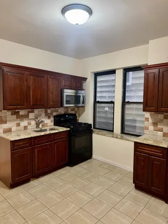 a kitchen with stainless steel appliances granite countertop a stove sink and cabinets