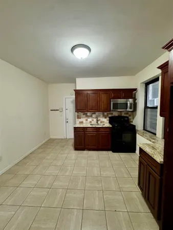 a kitchen with stainless steel appliances a refrigerator a sink a stove top oven and cabinets