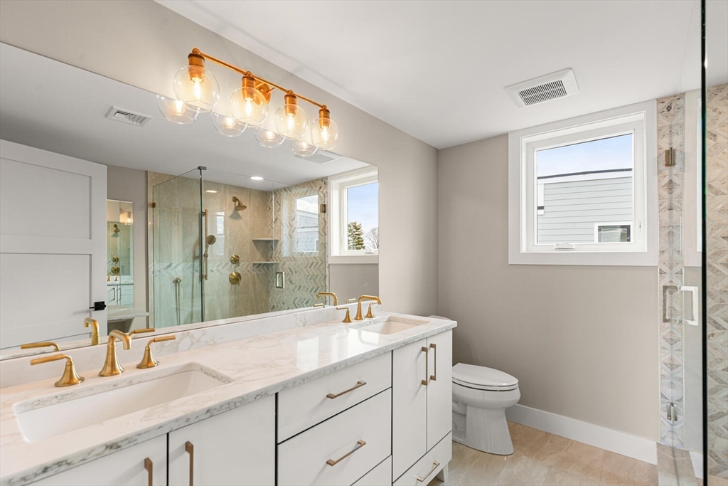 312 Newton Street, Unit 1A Waltham, MA 02453 - Photo 25 of 32 a bathroom with a granite countertop sink a toilet and a mirror