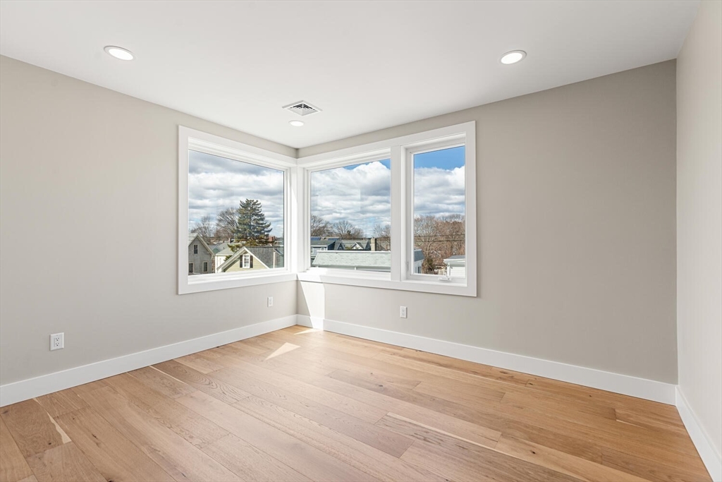 312 Newton Street, Unit 1A Waltham, MA 02453 - Photo 29 of 32 a view of an empty room with wooden floor and a window