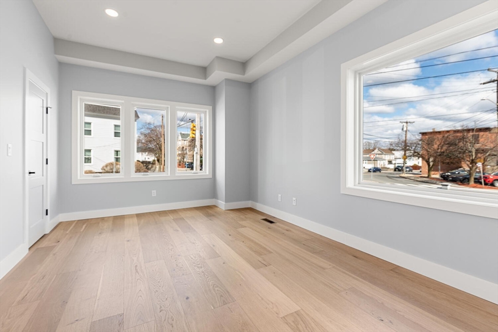 312 Newton Street, Unit 1A Waltham, MA 02453 - Photo 31 of 32 a view of an empty room with a window and wooden floor