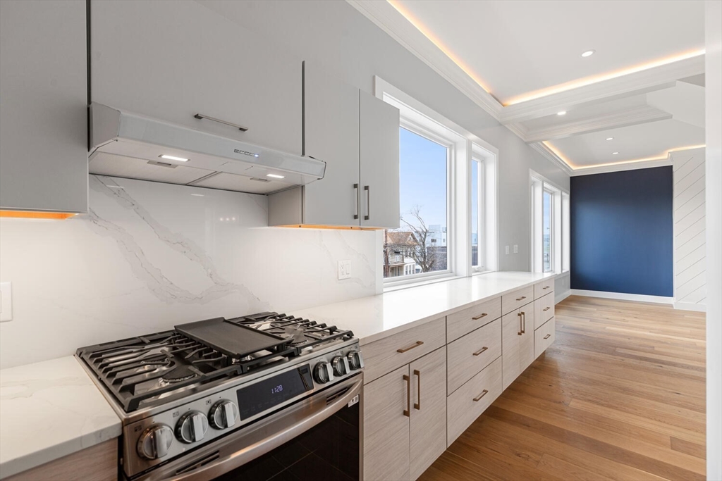 312 Newton Street, Unit 1A Waltham, MA 02453 - Photo 6 of 32 a kitchen with stainless steel appliances a stove and white cabinets