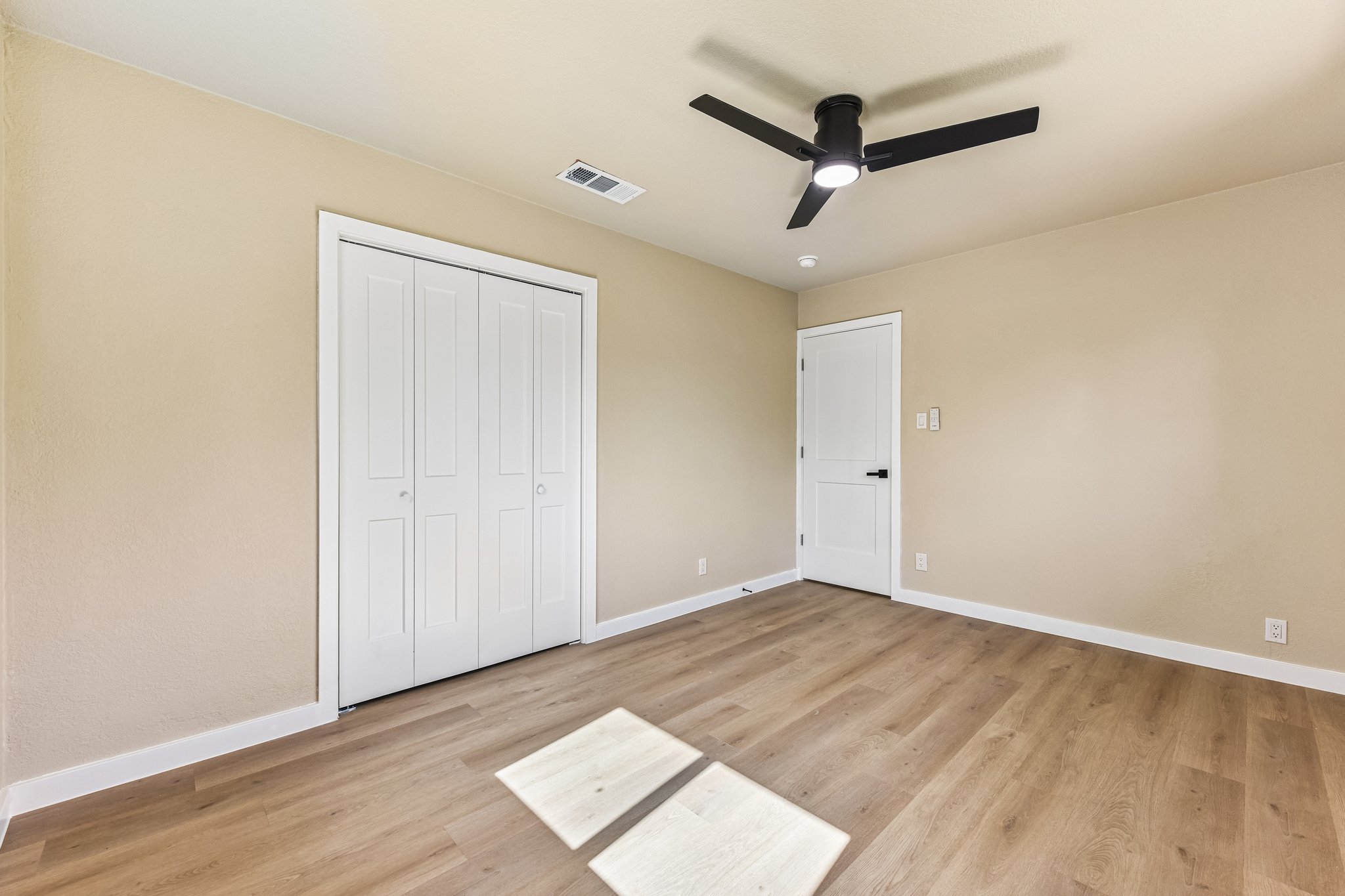 7523 Glenhill Road Austin, TX 78752 - Photo 24 of 38 An airy bedroom with light wood flooring features a contemporary ceiling fan.