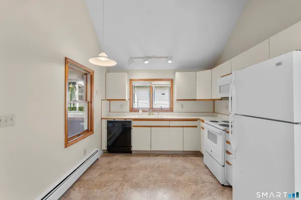 a kitchen with white cabinets and white appliances