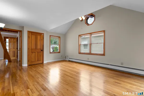an empty room with wooden floor and windows