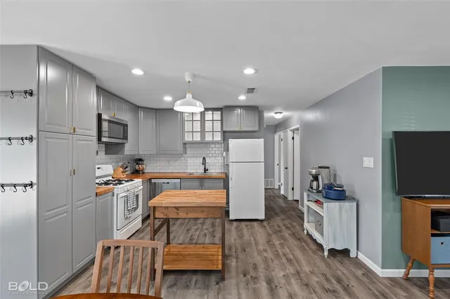 a kitchen with stainless steel appliances granite countertop a refrigerator and a stove top oven