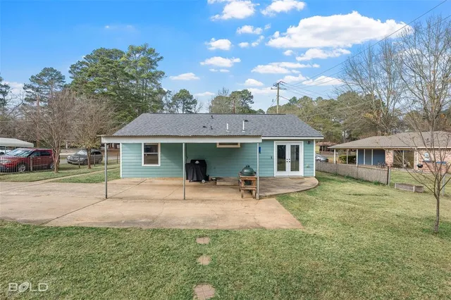 a patio with a table and chairs and potted plants