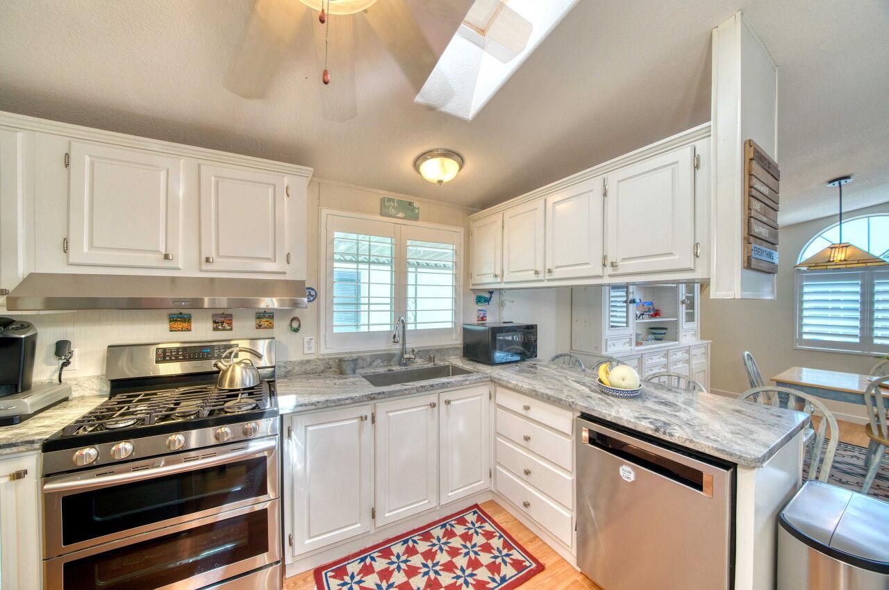 5 Lighthouse Road, Unit 5 Half Moon Bay, CA 94019 - Photo 10 of 25 a kitchen with stainless steel appliances granite countertop a stove a sink and a microwave