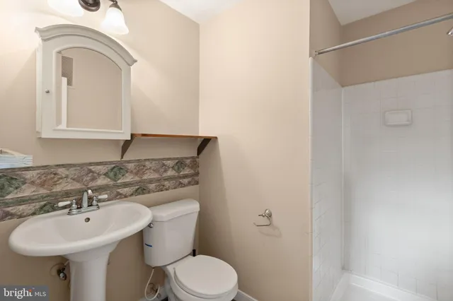 a bathroom with a sink toilet and a mirror