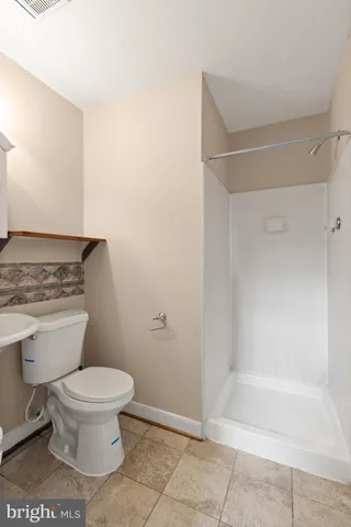 a bathroom with a toilet and a shower