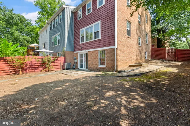 a view of a brick house with many windows next to a road