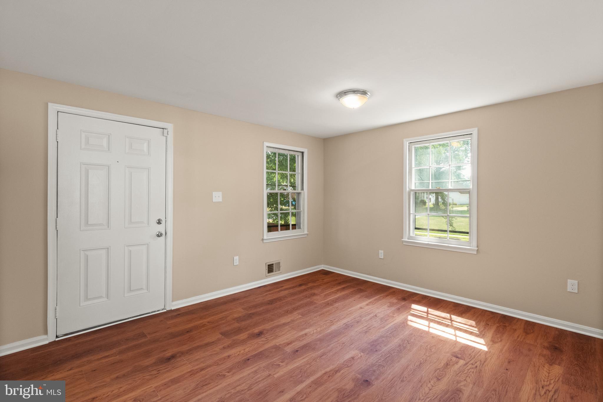 13143 Putnam Circle Woodbridge, VA 22191 - Photo 6 of 38 an empty room with wooden floor and windows