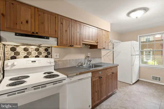 a kitchen with a sink a stove and cabinets