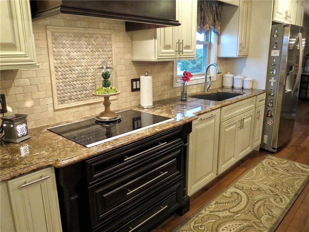175 Cedar Ridge Drive Monaca, PA 15061 - Photo 4 of 25 Kitchen features granite counter tops, SS appliances, maple & cherry cabinetry with soft close design, maple hardwood floors & travertine tile with inlay accent.