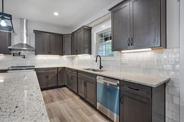 a kitchen with stainless steel appliances granite countertop a sink stove and cabinets