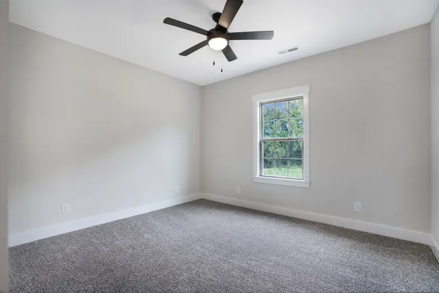 a bathroom with a toilet a sink a mirror and a window