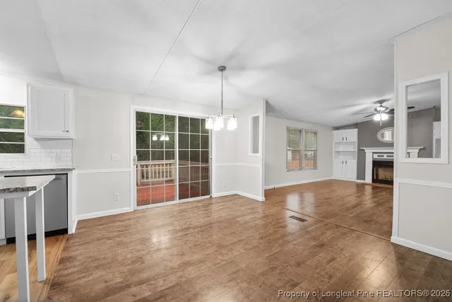 a view of an empty room with window and cabinet