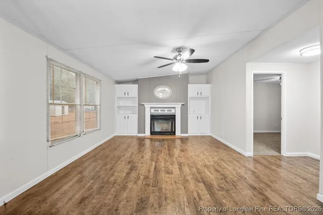 a view of an empty room with window and fire place
