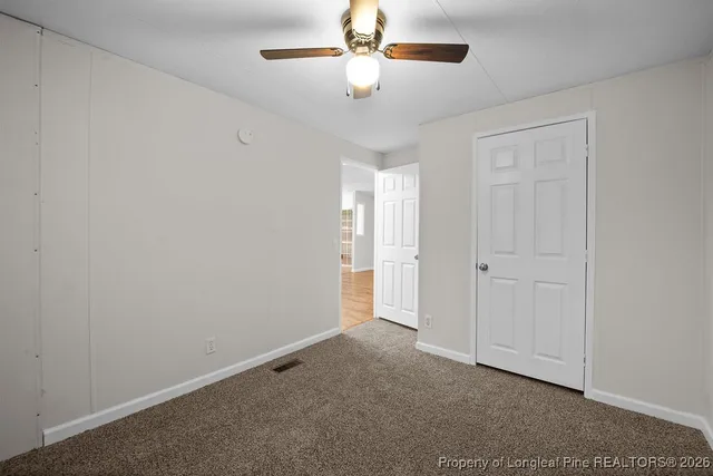a view of an empty room and a ceiling fan window