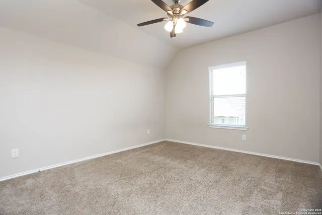 an empty room with a window and a fan