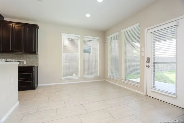 a view of an empty room with a fireplace and a window