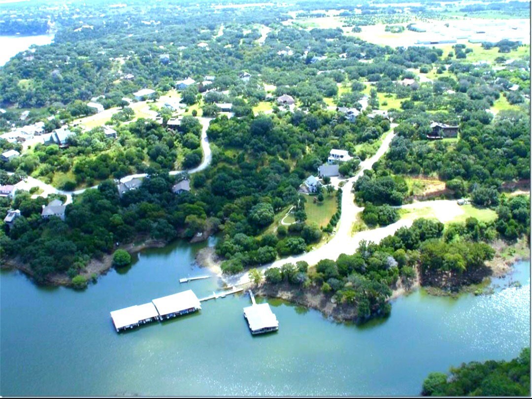an aerial view of a residential houses with yard and lake view